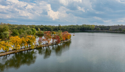 Fototapeta premium Aerial View of Nanjing Botanical Garden's Crescent Dike: Autumn Lakeside and City Skyline