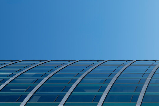 Modern blue glass facade with windows and grid pattern in abstract architecture detail featuring copyspace and clean corporate style