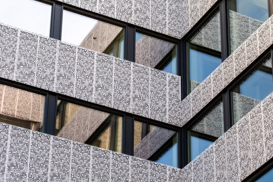 Modern concrete facade in architecture with windows corner texture and geometric pattern creating an abstract urban detail with clear rhythm