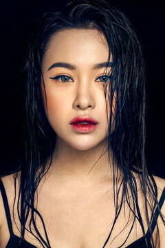 Asian girl with wet hair against a black background