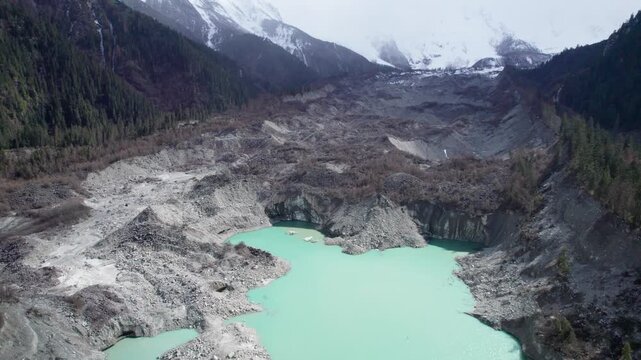 Drone view of Zhuxi glacier in Bomi County, Nyingchi, Tibet, China. High angle view of beautiful green glacial barrier lake among forest and gray rock, 4k real time footage b roll shot, travel concept