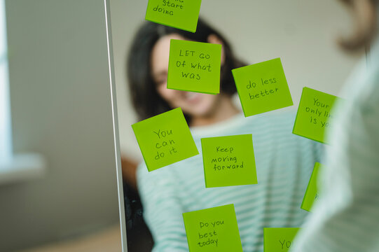 Positive affirmations on green sticky notes on a mirror