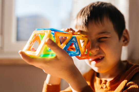 Looking through a colorful magnetic block constructor toy at home