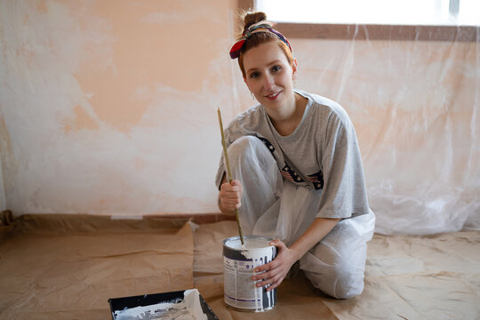 Smiling painter stirring paint during indoor home renovation
