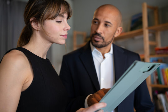 Businesswoman and businessman discussing document in office