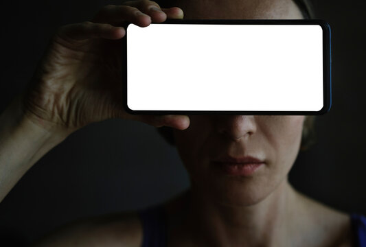Woman holding smartphone mockup over eyes for digital privacy