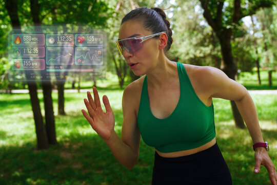 Runner jogging in park with futuristic holographic fitness dashboard