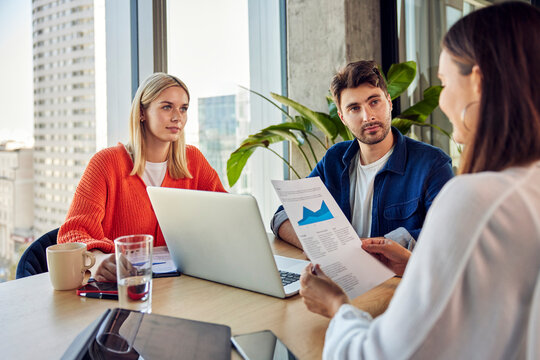 Businesswoman discussing with colleagues over data in office