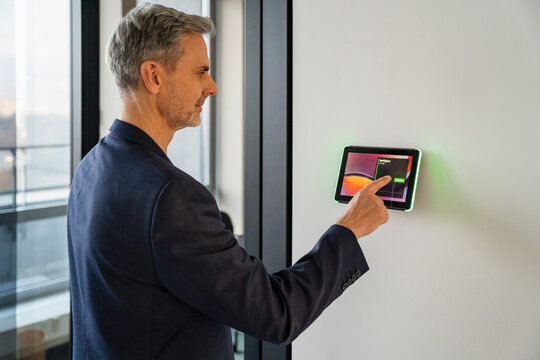 Businessman using a tablet to book an office indoors