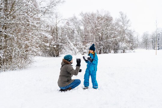 Family having fun playing with snow outdoors in winter