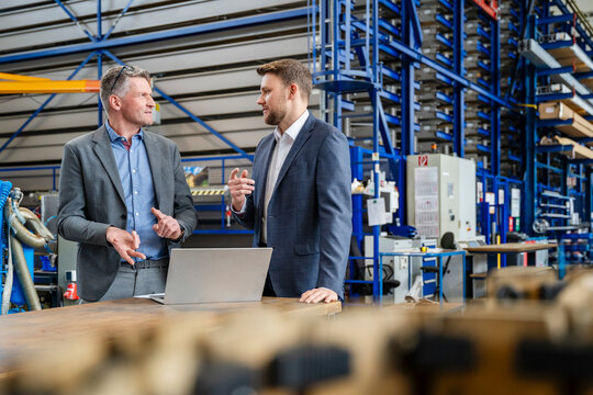 Managers having a business discussion in a production hall