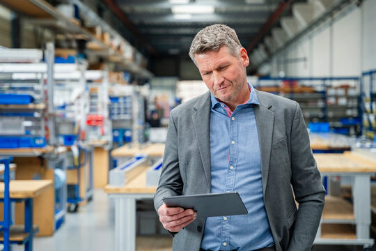 Manager working on a digital tablet in a production hall
