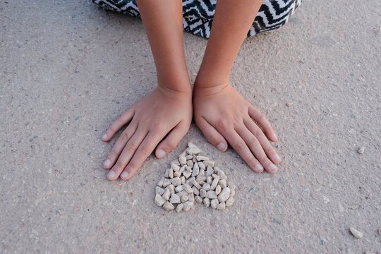 Hands touching heart shaped stones outdoors expressing love and care