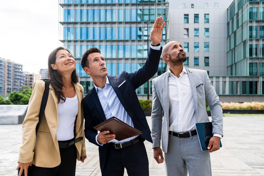 Corporate team looking up at office building in financial district