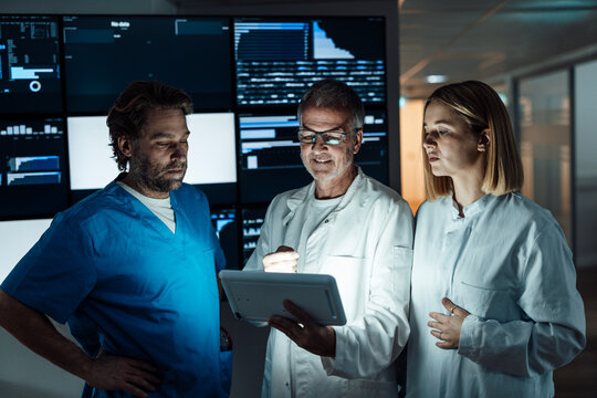 Medical team analyzing tablet data in hospital