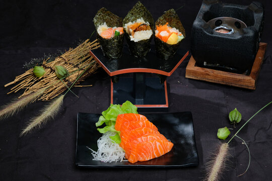Close-up shot of a white dish of unagi sushi set, Japanese food serving on the clear white table with japanese tea cup and many japanese stye decoration in background