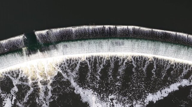 Drone shot looking straight down at a river weir water infrastructure and migratory fish pass