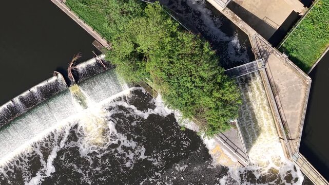 Drone shot looking straight down at a river weir water infrastructure and migratory fish pass