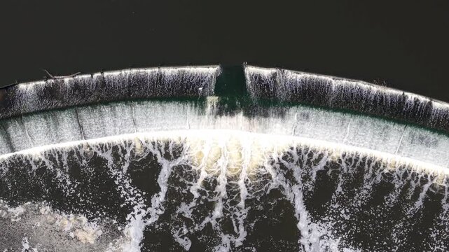 Drone shot looking straight down at a river weir water infrastructure and migratory fish pass
