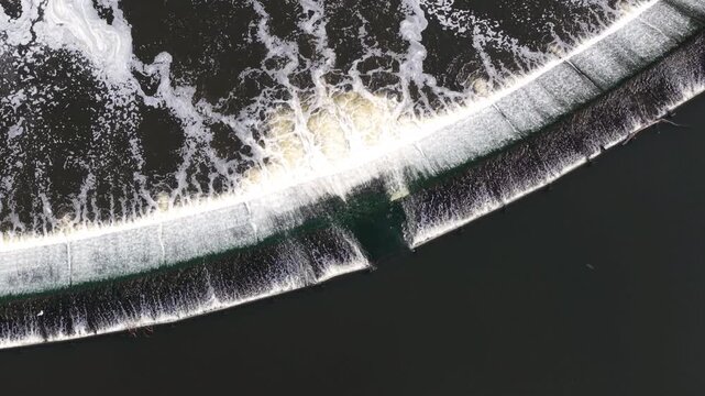 Top down aerial view of Knottingley Weir with cascading water and center fish passage notch UK