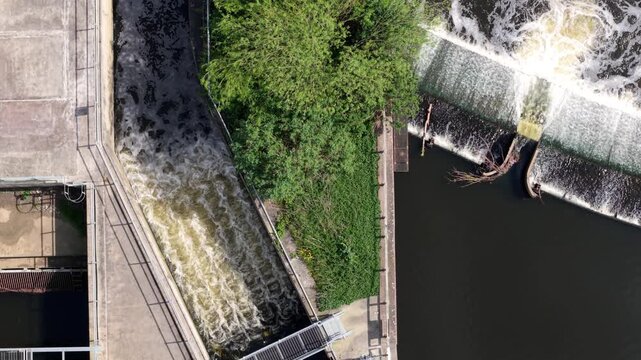 Top down aerial view of Knottingley Weir with cascading water a center fish pass and hydroelectric power station UK