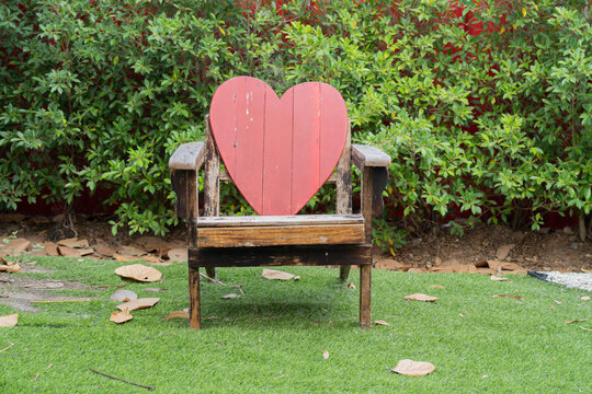 Wooden lounge Adirondack chair at garden. Outdoor summer vacation heart leisure relaxation seat