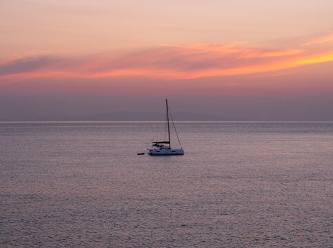 Yacht at sunset in the Aegean Sea on Mykonos island in Greece