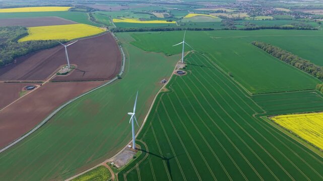 Aerial drone view of Marr Wind Farm wind turbines surrounded by multicolored rural fields and paddocks in Yorkshire UK