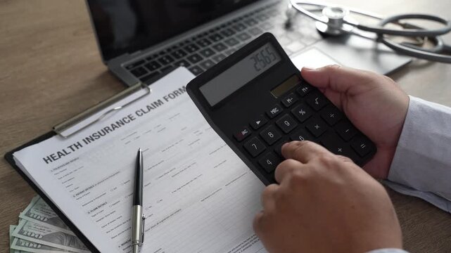 Healthcare cost calculator on health insurance claim form with US dollar bills, stethoscope, and pen on laptop, medical financial planning for hospital expenses and policy coverage budget.