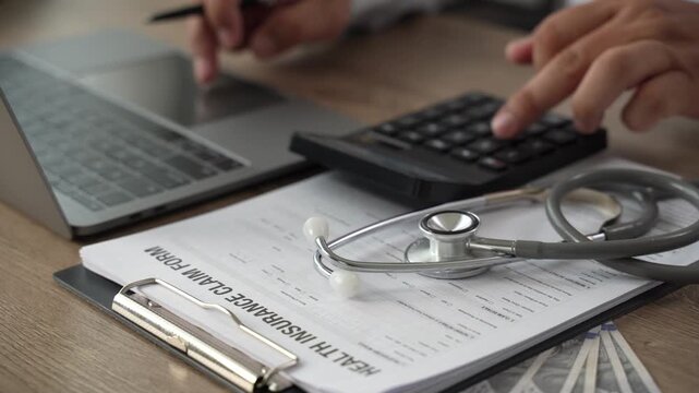 Healthcare cost calculator on health insurance claim form with US dollar bills, stethoscope, and pen on laptop, medical financial planning for hospital expenses and policy coverage budget.