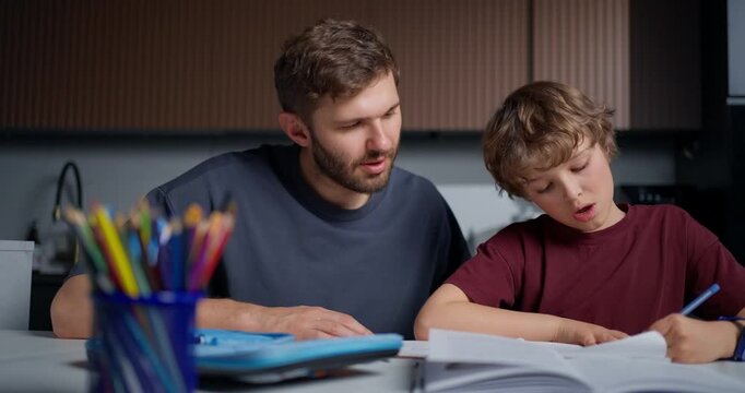 Gentle Parent Helps Boy With Homework. Peaceful Scene Of Father Teaching Son With Patience And Care