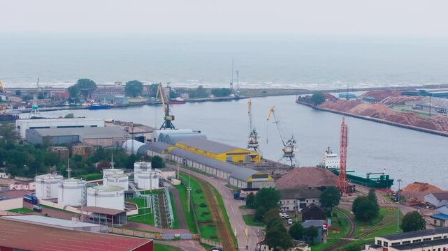 Aerial rise shows Liepaja harbor cargo zones and truck driving onto roadway