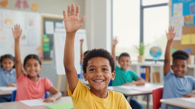 Happy black student raising his hand in classroom. Eager elementary school boy participating in lesson with diverse classmates. Education and active learning concept