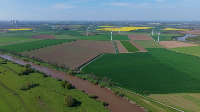 High angle aerial drone view of a large onshore wind turbine farm in colorful rural patchwork agricultural fields near Airmyn United Kingdom