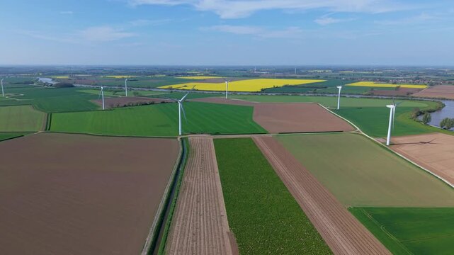 High angle aerial drone view of a large onshore wind turbine farm in colorful rural patchwork agricultural fields near Airmyn United Kingdom
