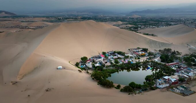 Scenic Huacachina desert oasis nestled between dunes in Peru, aerial view