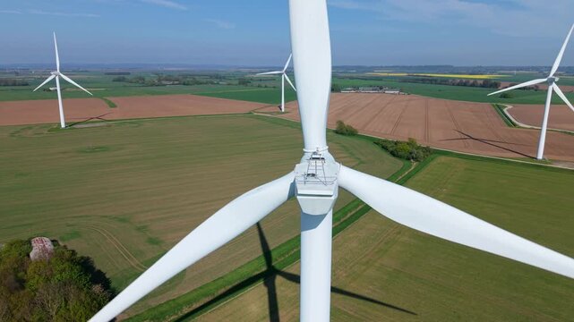 High angle aerial drone view of Keadby wind farm with rows of wind turbines generating clean electricity across colorful rural fields in North Lincolnshire England UK