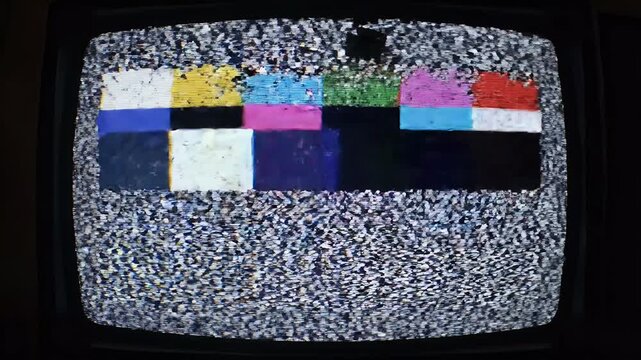 A close-up view of a vintage television screen displaying static and colorful interference patterns, evoking a sense of nostalgia and technological obsolescence.