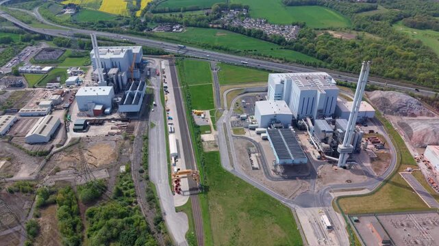 High angle aerial view tracking past twin industrial waste processing plants reducing landfill reliance