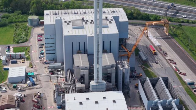 Aerial view of twin modern energy from waste power plants processing municipal refuse for sustainable electricity