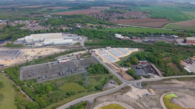 Aerial view of an electrical substation and Battery Energy Storage System BESS with an industrial facility background in Ferrybridge, UK.