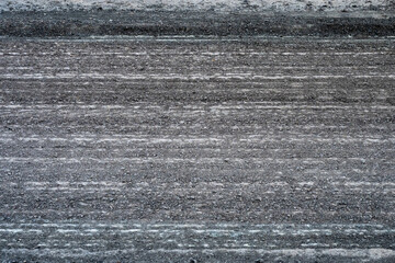 a milled asphalt road surface, showcasing a dense, linear pattern of grooved textures from industrial roadwork machinery © Andrey