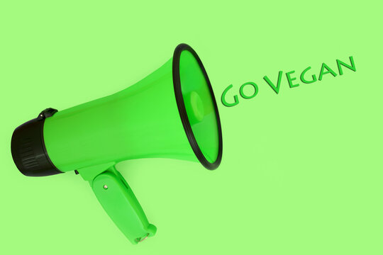 Go vegan slogan with megaphone loudspeaker on green background. Environmental conservation, save, protect nature and the earth concept.
