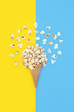 Abstract food art popcorn ice cream cornet design on blue yellow background. Surreal summer fun bizarre design for greeting card.