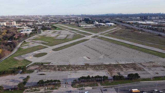 A high-angle aerial view of a decommissioned circular compass rose marked with a white "X" on the tarmac of the closed Buttonville Municipal Airport in Markham, Ontario