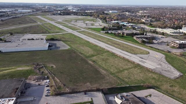 A high-angle aerial view of the closed Buttonville Municipal Airport, showing empty runways, taxiways, and surrounding industrial development in the Greater Toronto Area