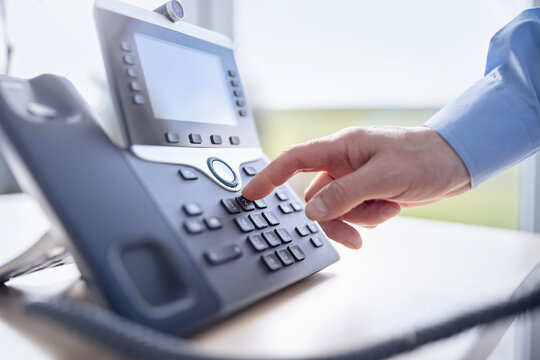 Dialing a telephone in the office, communication, contact us and customer service support
