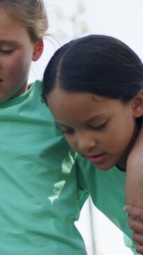 Vertical video: Hearing off-camera cue, three girls linking arms, posing at park, light green tees