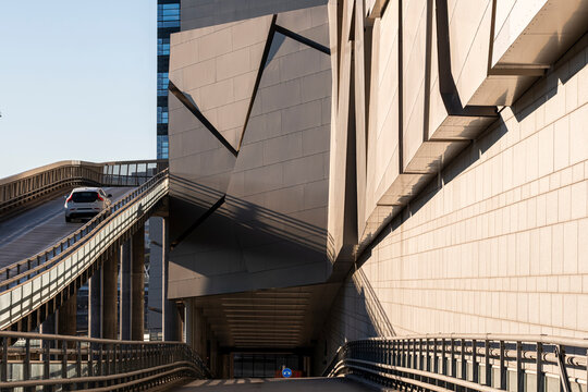 Concrete ramp overpass above stockholm road with car movement shows urban infrastructure in sunlight with sweeping perspective for daily commute