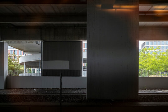 Concrete viaduct underpass in urban berlin architecture uses framing and shadow in daylight to guide deep perspective through empty space